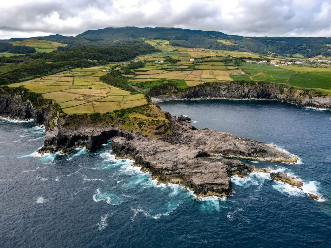 Rugged coastline with green fields and blue ocean